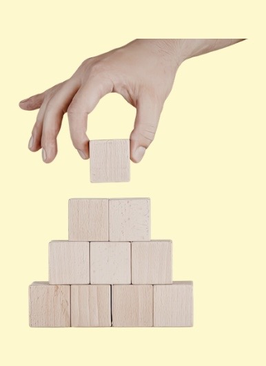 Hand die einen Holzturm baut